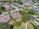 Aerial view of a home with a screened in porch and mature landscaping in a well maintained lakeside community at 6122 Sailboat Ave, Tavares, FL 32778