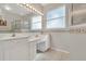 Bright bathroom with double sink vanity, Hollywood lights, and a shower with a glass door at 6122 Sailboat Ave, Tavares, FL 32778