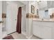 Bathroom with tiled floor, shower with curtain, and white vanity cabinet with framed mirror at 6122 Sailboat Ave, Tavares, FL 32778
