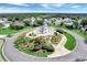 Aerial view of a lighthouse and manicured landscaping in the center of a well maintained lakeside community at 6122 Sailboat Ave, Tavares, FL 32778
