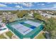 Aerial view of the community tennis courts with bleachers for spectators in a well maintained lakeside community at 6122 Sailboat Ave, Tavares, FL 32778