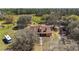 Aerial view of a home with brick chimney, surrounded by lush greenery and a long driveway at 6813 S Fork Ranch Dr, Clermont, FL 34714
