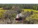 Aerial shot of a red barn nestled among green trees showing a rural charm and character at 6813 S Fork Ranch Dr, Clermont, FL 34714