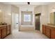 Luxurious bathroom features dual vanities, a standalone shower, and a soaking tub with a decorative window at 6813 S Fork Ranch Dr, Clermont, FL 34714