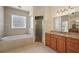 Elegant bathroom features a soaking tub, glass shower, and vanity with granite countertops at 6813 S Fork Ranch Dr, Clermont, FL 34714