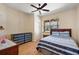 Cozy bedroom featuring wood floors, ceiling fan, dresser, and large window views at 6813 S Fork Ranch Dr, Clermont, FL 34714