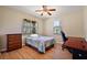 Bright bedroom with a wood floor, large windows, ceiling fan, desk, and wooden dresser at 6813 S Fork Ranch Dr, Clermont, FL 34714