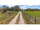 Long dirt driveway leading to the property, lined with fencing on both sides at 6813 S Fork Ranch Dr, Clermont, FL 34714