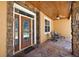 Charming front porch with decorative wood door, wood ceilings, and natural stone elements at 6813 S Fork Ranch Dr, Clermont, FL 34714