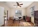 Sunlit living room with hardwood floors, a cozy white couch, and expansive windows offering scenic views at 6813 S Fork Ranch Dr, Clermont, FL 34714