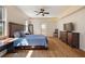 Bedroom with wood floors, ceiling fan, and a doorway leading to the en suite bathroom at 6813 S Fork Ranch Dr, Clermont, FL 34714