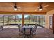 Back patio with wood ceiling, dining table set, and screened in porch at 6813 S Fork Ranch Dr, Clermont, FL 34714