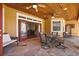 Covered patio with stone floor, wood ceiling, dining set, and comfortable seating at 6813 S Fork Ranch Dr, Clermont, FL 34714