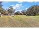 Wide view of the acreage, showcasing a well-maintained lawn, mature trees, and the home in the distance at 6813 S Fork Ranch Dr, Clermont, FL 34714