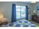 Bright bedroom with a large window view, complemented by elegant lamps and vintage wood dresser at 773 Artesia Ave, The Villages, FL 32162