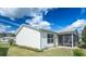 Rear exterior view showing the screened-in lanai and the well-kept backyard at 773 Artesia Ave, The Villages, FL 32162