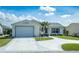 Charming single-story home with a well-manicured lawn, a two-car garage and a clean, painted driveway at 773 Artesia Ave, The Villages, FL 32162