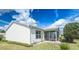 Rear exterior view showcasing a cozy screened lanai and well-manicured backyard space at 773 Artesia Ave, The Villages, FL 32162