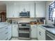 Bright kitchen features white cabinets, stainless steel appliances, and light countertops at 773 Artesia Ave, The Villages, FL 32162