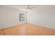 A clean, airy bedroom with wood floors, a ceiling fan, and a window overlooking the serene outdoors at 776 Alcott Ave, The Villages, FL 32162