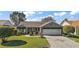 Attractive single-story home with paver driveway, well-maintained lawn, and mature landscaping at 776 Alcott Ave, The Villages, FL 32162