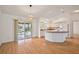 Spacious living room with wood floors and view to adjacent kitchen and screened patio at 776 Alcott Ave, The Villages, FL 32162
