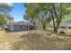 Large backyard with mature trees, chairs around the fire pit, and a single-story home at 804 Deep Wood Ct, Fruitland Park, FL 34731