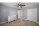 A bedroom features light blue walls, a ceiling fan, light wood floors, and a white dresser with matching closet doors at 804 Deep Wood Ct, Fruitland Park, FL 34731