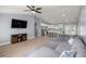 An open-concept living room flows into a kitchen with white cabinets, a gray sectional, and a ceiling fan at 804 Deep Wood Ct, Fruitland Park, FL 34731