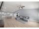 An open-concept living room has high ceilings, a ceiling fan, and light wood flooring, next to the kitchen and dining area at 804 Deep Wood Ct, Fruitland Park, FL 34731