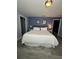 Bright bedroom features a comfortable bed, modern gray floors, and a soft blue accent wall at 8973 Cat Palm Rd, Kissimmee, FL 34747