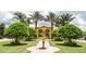 Community clubhouse entrance with manicured landscaping and palm trees in the background at 8973 Cat Palm Rd, Kissimmee, FL 34747
