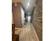 Inviting hallway with wood-look flooring and a stylish accent wall, leading to other areas of the home at 8973 Cat Palm Rd, Kissimmee, FL 34747