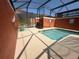 Enclosed pool area with a barbecue, potted plants, and a shallow end, creating a relaxing outdoor space at 8973 Cat Palm Rd, Kissimmee, FL 34747