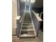 Staircase with light gray floors, a white handrail, and blue walls leading upstairs at 8973 Cat Palm Rd, Kissimmee, FL 34747