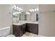 Bathroom with dual sinks, dark cabinets, granite counters, and large mirror at 1017 Green Gate Blvd, Groveland, FL 34736