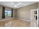 Empty bedroom with tile floor, neutral walls and a large window and door to the hall at 1017 Green Gate Blvd, Groveland, FL 34736