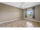Cozy bedroom with a large window, neutral walls, and tile flooring at 1017 Green Gate Blvd, Groveland, FL 34736