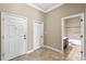 Hallway with ceramic tile floors, neutral color walls, and multiple doors, leading to the bathroom at 1017 Green Gate Blvd, Groveland, FL 34736