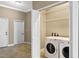 Bright laundry room with white washer and dryer and convenient shelving at 1017 Green Gate Blvd, Groveland, FL 34736