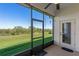 Screened in porch with a ceiling fan offering serene views of a lush green landscape at 1017 Green Gate Blvd, Groveland, FL 34736