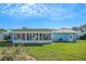 Enclosed sunroom extends from the back of the home, complemented by a lush green lawn at 1033 Scotch Pine Ct, Leesburg, FL 34788