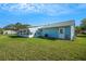 Backyard view features a sunroom addition and a well-kept lawn, enhancing the home's outdoor appeal at 1033 Scotch Pine Ct, Leesburg, FL 34788
