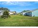 Expansive backyard view showcasing well-maintained lawns and neighboring homes under a clear blue sky at 1033 Scotch Pine Ct, Leesburg, FL 34788