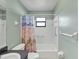 Bright bathroom featuring a tub/shower combo with a shower curtain and a granite vanity at 1033 Scotch Pine Ct, Leesburg, FL 34788
