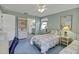 Inviting bedroom featuring two twin beds, a window, and comfortable blue carpet at 1033 Scotch Pine Ct, Leesburg, FL 34788