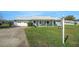 Inviting single-story home featuring a well-manicured front lawn and an attached two-car garage at 1033 Scotch Pine Ct, Leesburg, FL 34788