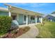 Inviting front porch with white columns, complemented by a landscaped garden bed, creating a welcoming entry at 1033 Scotch Pine Ct, Leesburg, FL 34788