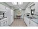 Well-lit kitchen with white appliances, tile floors, and view into breakfast nook and dining room at 1033 Scotch Pine Ct, Leesburg, FL 34788