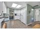 Bright kitchen with white appliances, cabinetry, and tile flooring, view into dining room at 1033 Scotch Pine Ct, Leesburg, FL 34788